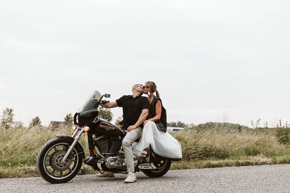 blog post our wedding story newlyweds on a harley motorcycle kissing