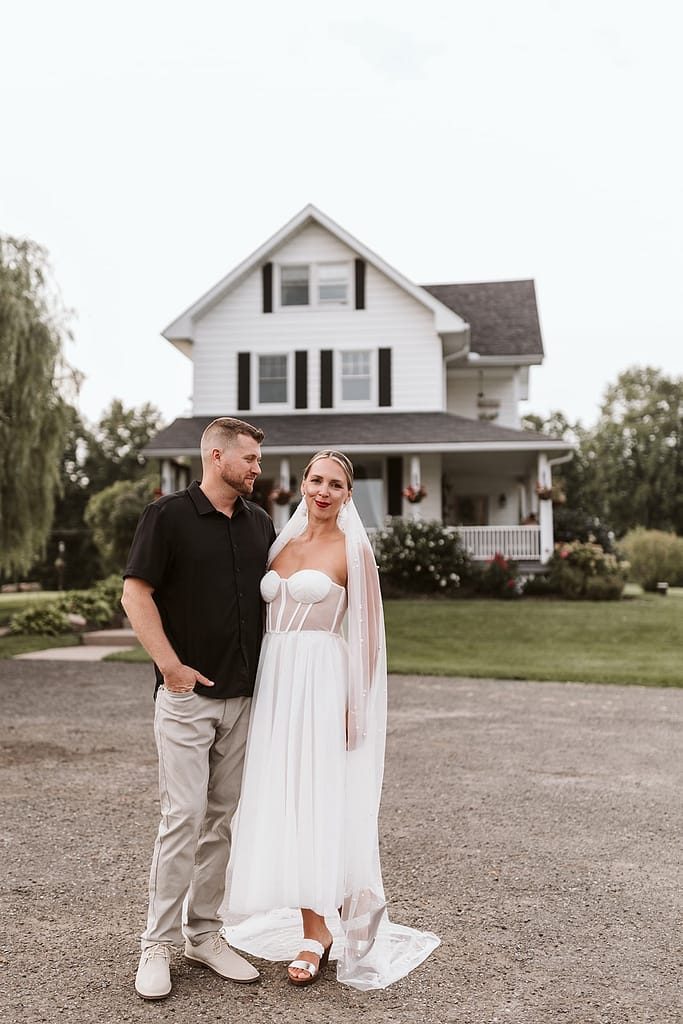 blog post our wedding story bride and groom in front of farmhouse
