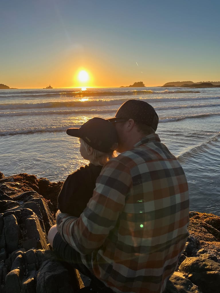 travelling after kids - dad and son watching sunset on beach tofino